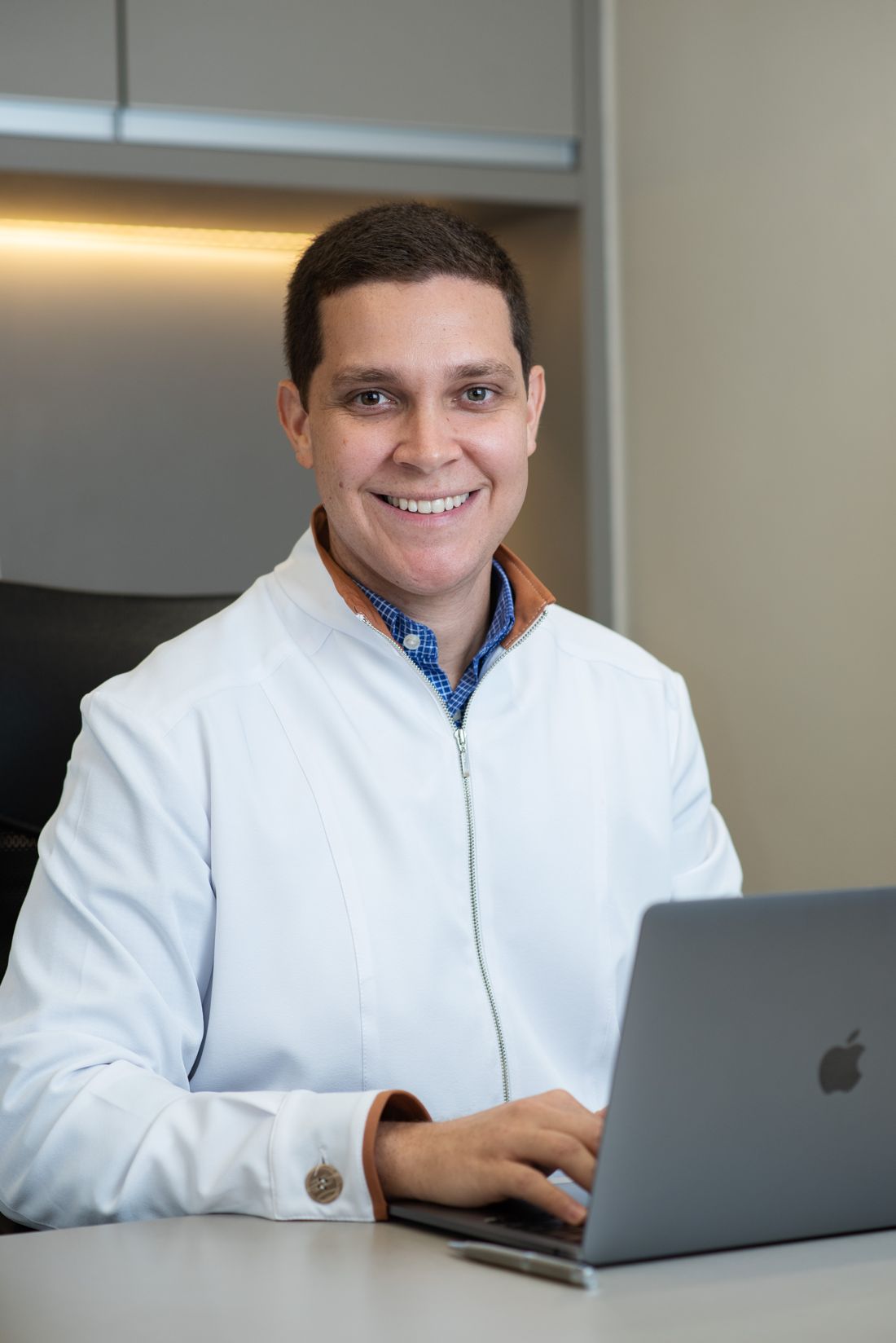 Dr. Leonardo Caporossi em sua mesa no consultório