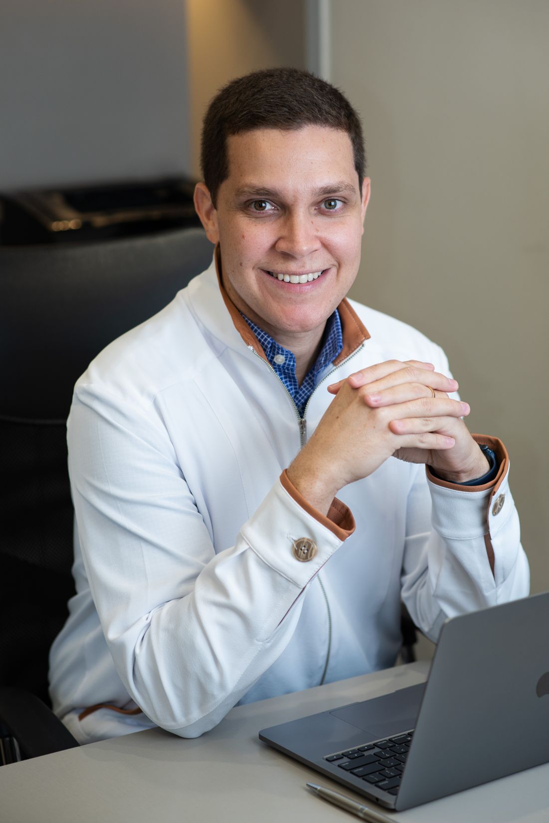 Dr. Leonardo Caporossi no consultório, de jaleco