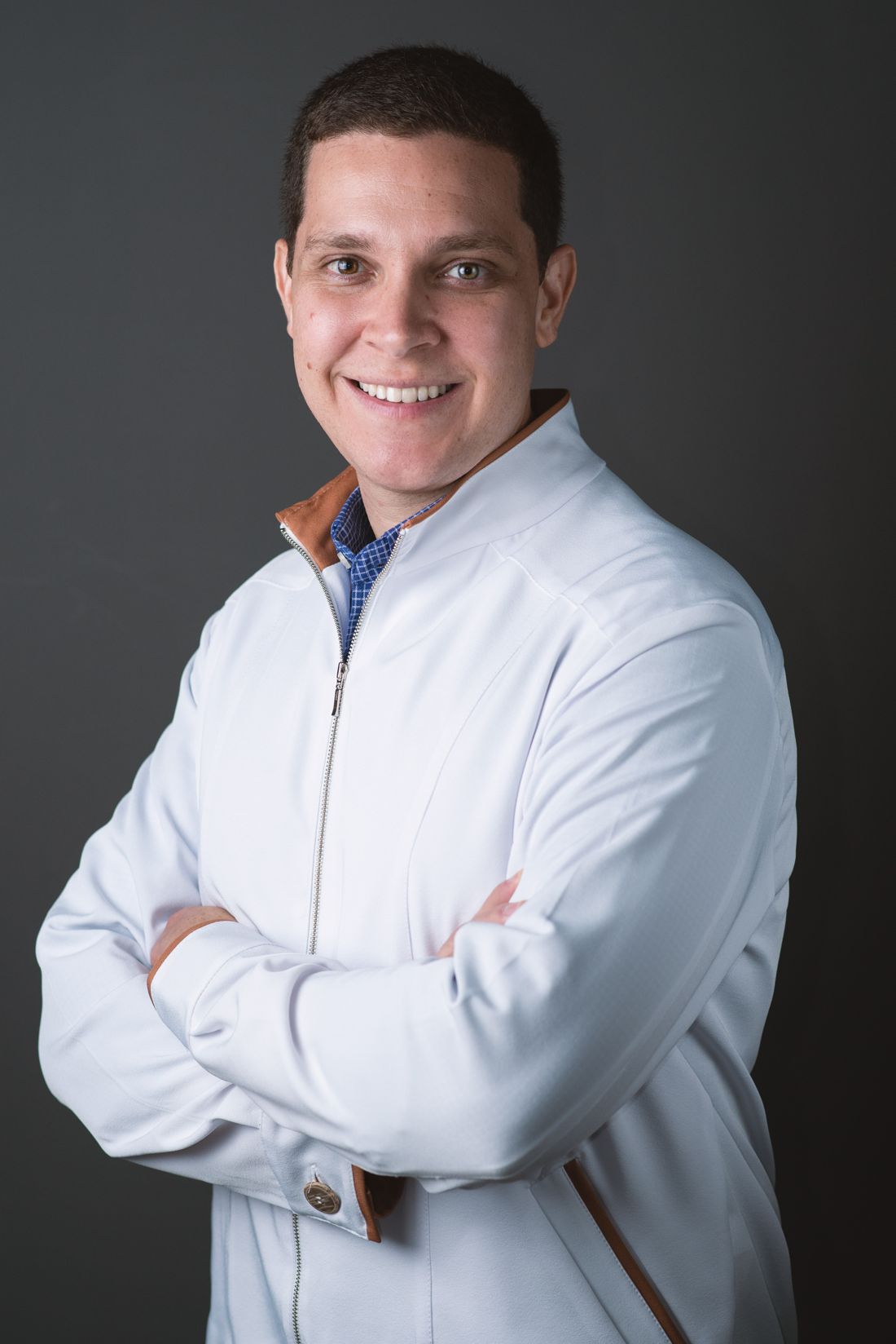 Dr. Leonardo Caporossi, de jaleco, sorrindo
